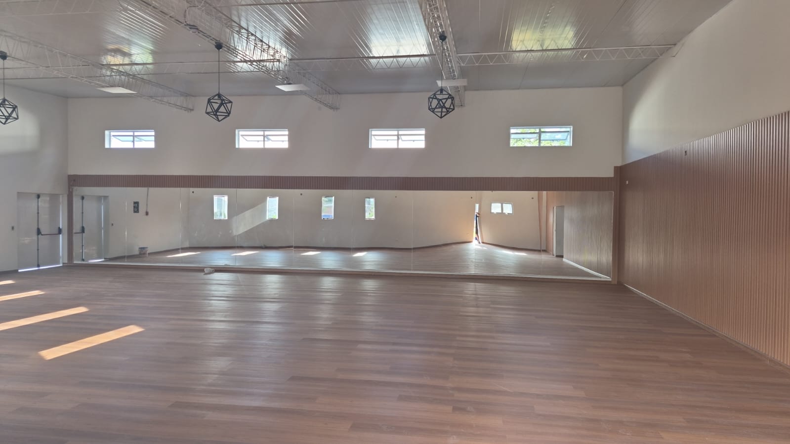 Interior amplio con piso de madera y espejo de muro